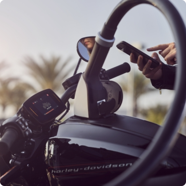 Person using their phone while charger is plugged into motorcyle