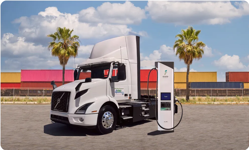 A 41 Volvo VNR truck next to a commercial charger 
