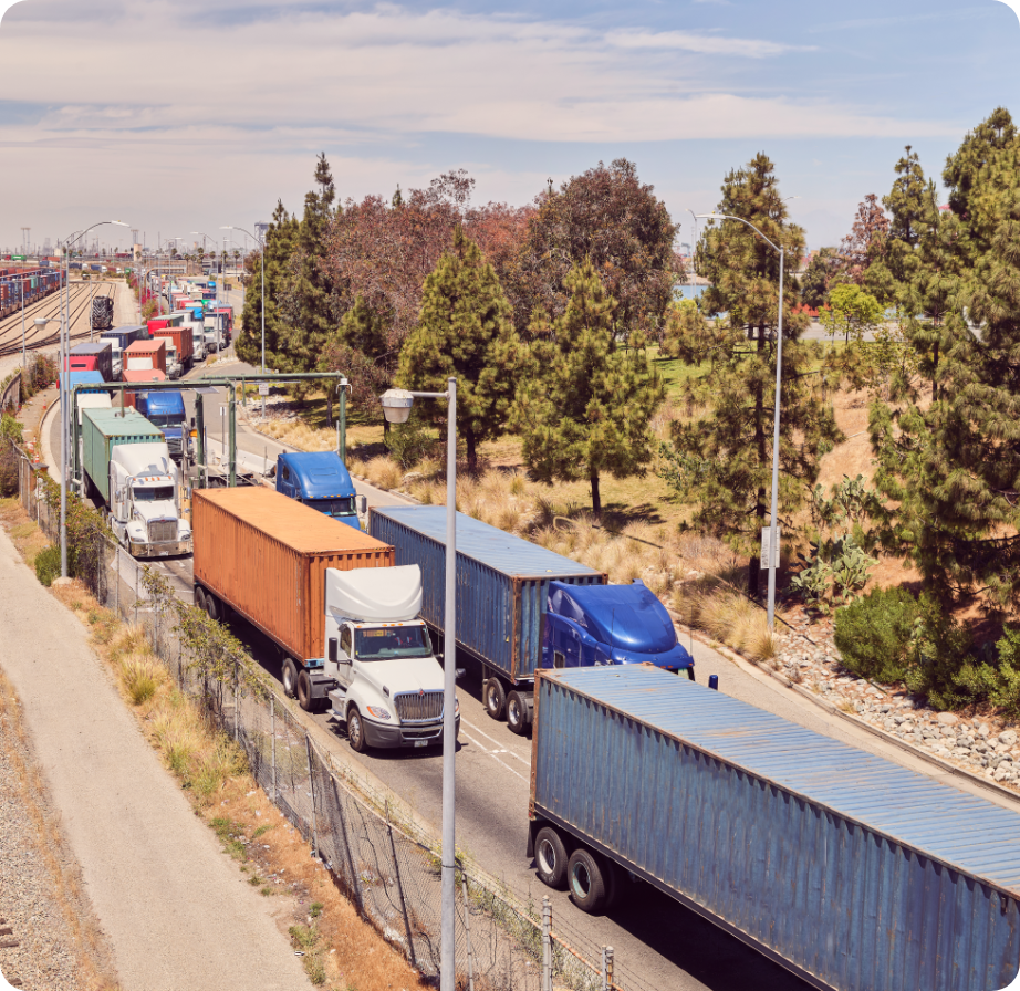 Aerial view of a highway with 18-wheel tractor-trailers transporting shipping containers