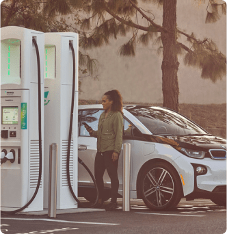 Woman using mobile device near an Electrify America charging station