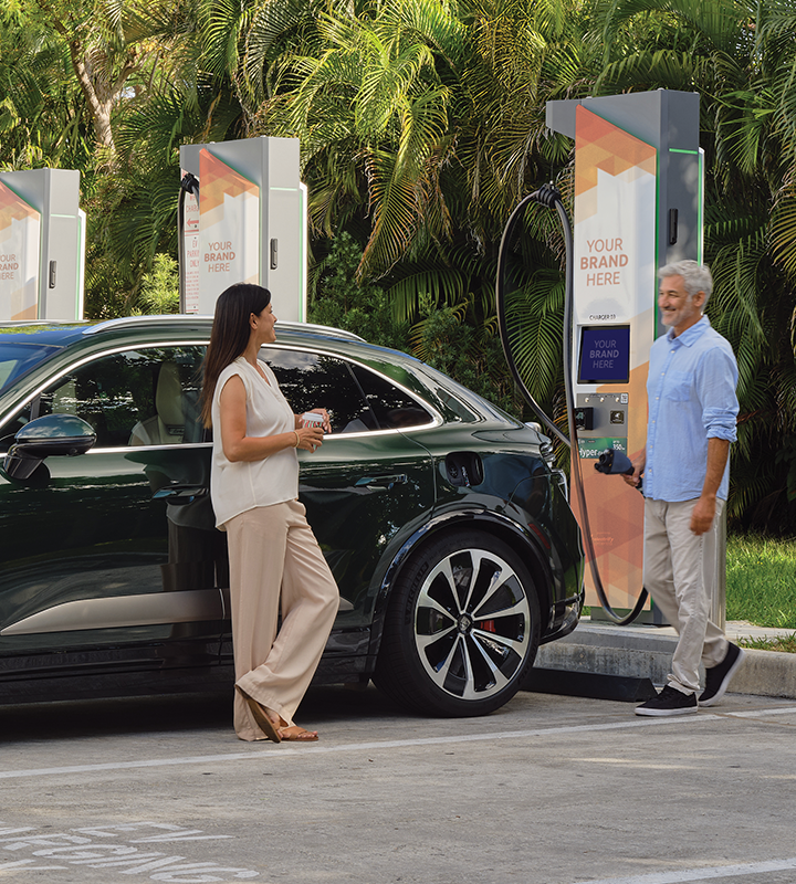 View of an EV charging at at an Electrify America station with the vehicle's owner.