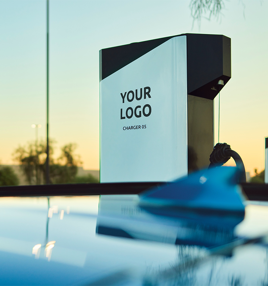 The roof of an EV with an Electrify America charging station and a sunset in the background.