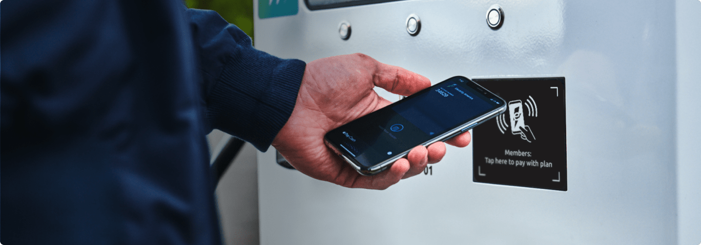 Closeup of a person making a contactless payment at an Electrify America charging station